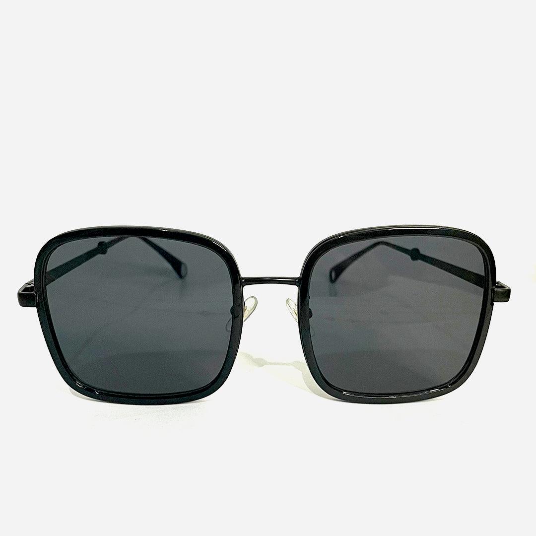 Óculos de sol Aviator Black com armação preta quadrada e lentes escuras, ideal para um estilo clássico e moderno.