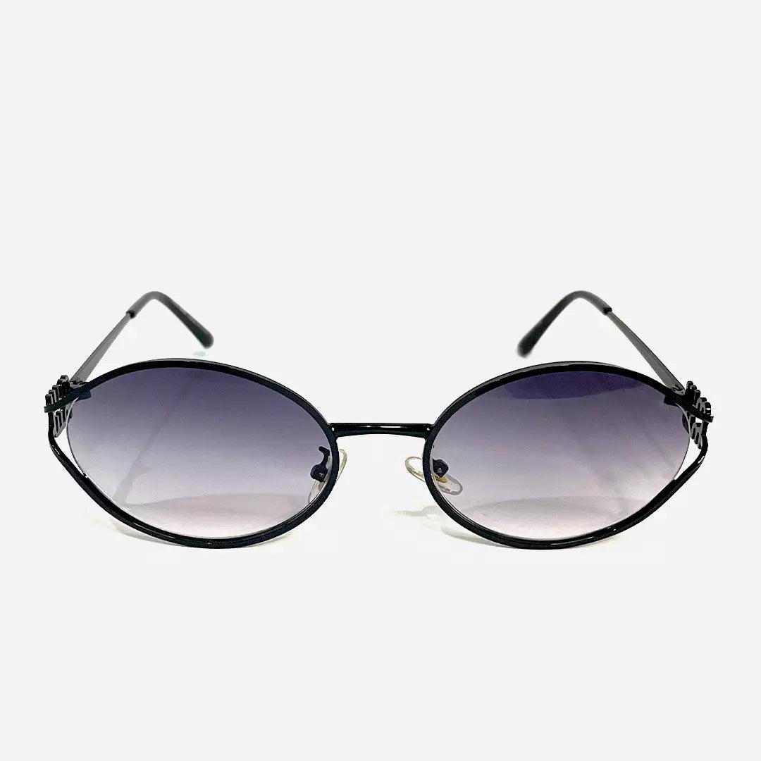 Óculos de sol Desert Black com armação preta elegante e lentes ovais em degradê escuro, proporcionando um visual sofisticado e moderno.