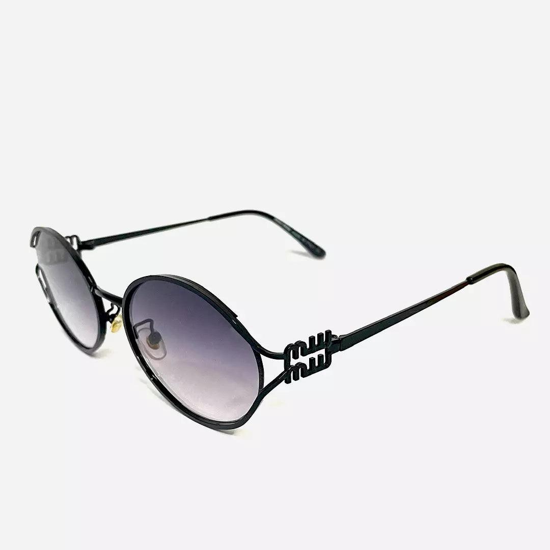 Óculos de sol Desert Black com armação preta minimalista, lentes ovais degradê e hastes finas detalhadas, ideal para um visual clássico e refinado.