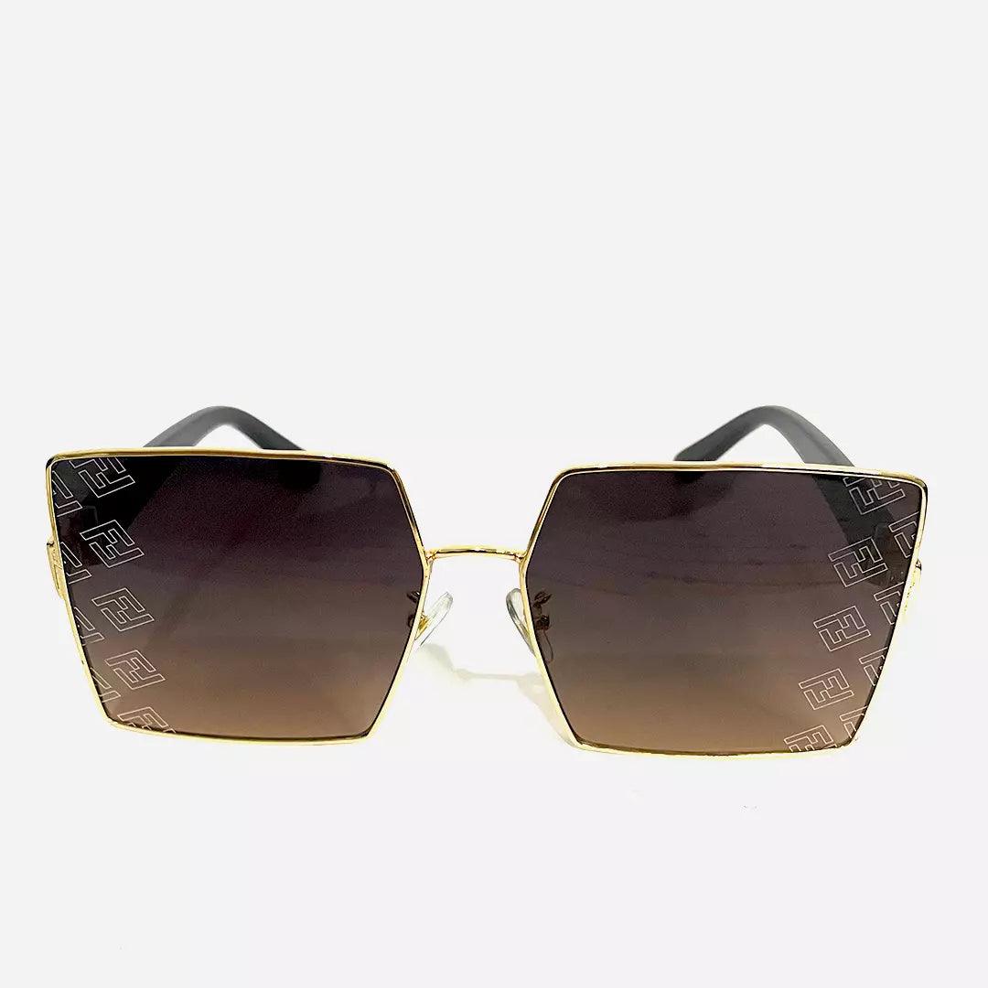 Óculos de sol Fuel Geometric com lentes degradê marrons, detalhes geométricos elegantes e armação dourada em design sofisticado.