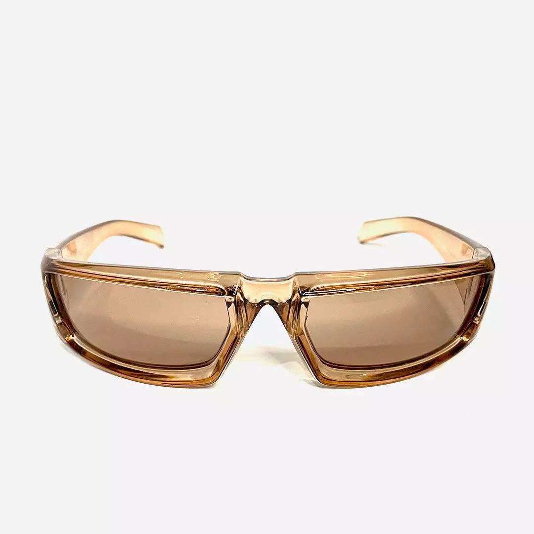 Óculos de sol Hype Ret com armação translúcida bege e lentes marrons, destacando um design retrô moderno. Ideal para complementar looks despojados com estilo único e personalidade.