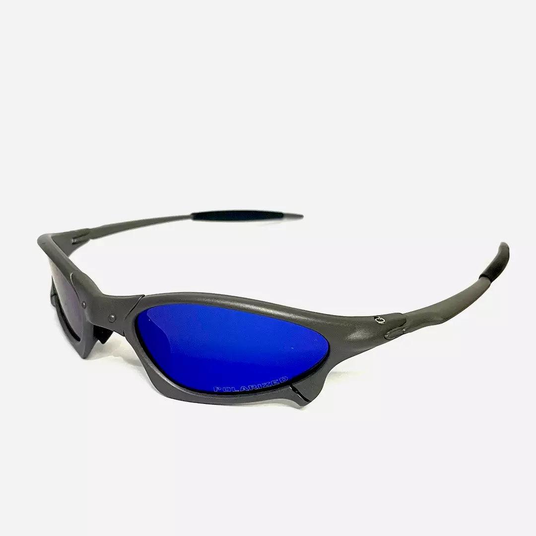 Óculos de sol Juliet com armação cinza fosca e lentes espelhadas azul profundo, visto de ângulo lateral que destaca o design aerodinâmico e esportivo. Modelo exclusivo da Lottus Unique, ideal para um visual moderno e dinâmico.