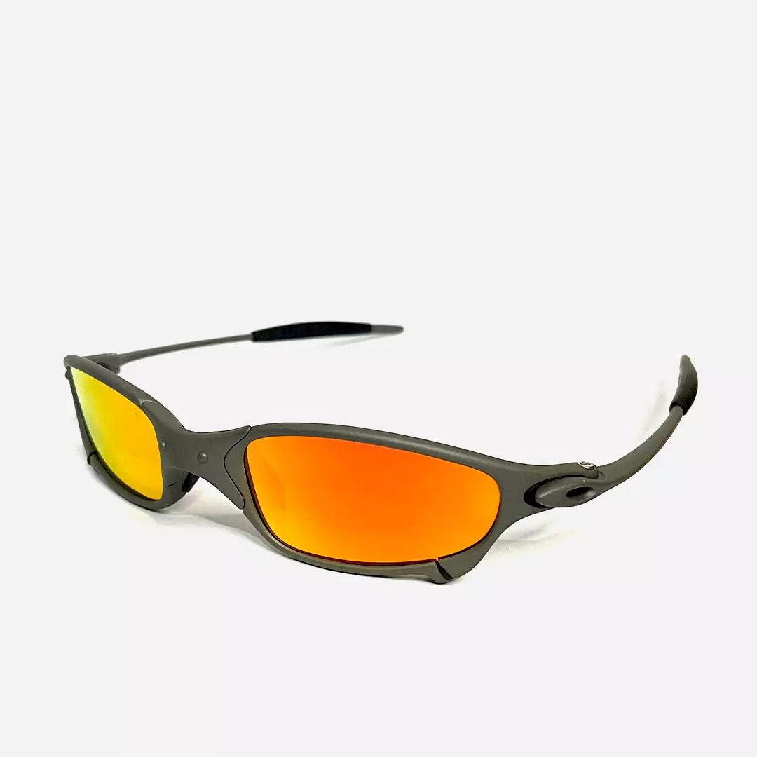 Óculos de sol Juliet com armação cinza fosca e lentes espelhadas em tom laranja neon, design aerodinâmico e moderno. Modelo esportivo exclusivo da Lottus Unique, ideal para atividades ao ar livre e looks ousados.