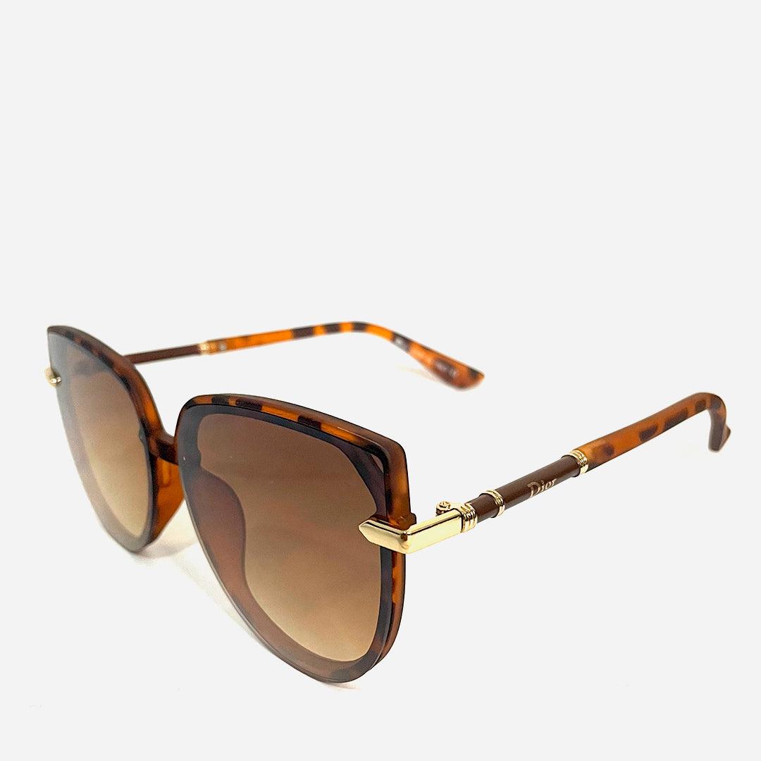 Óculos de sol Maria Carlota Tartaruga com armação estilo tartaruga, lentes degradê marrons e detalhes dourados, ideal para um visual elegante e contemporâneo.