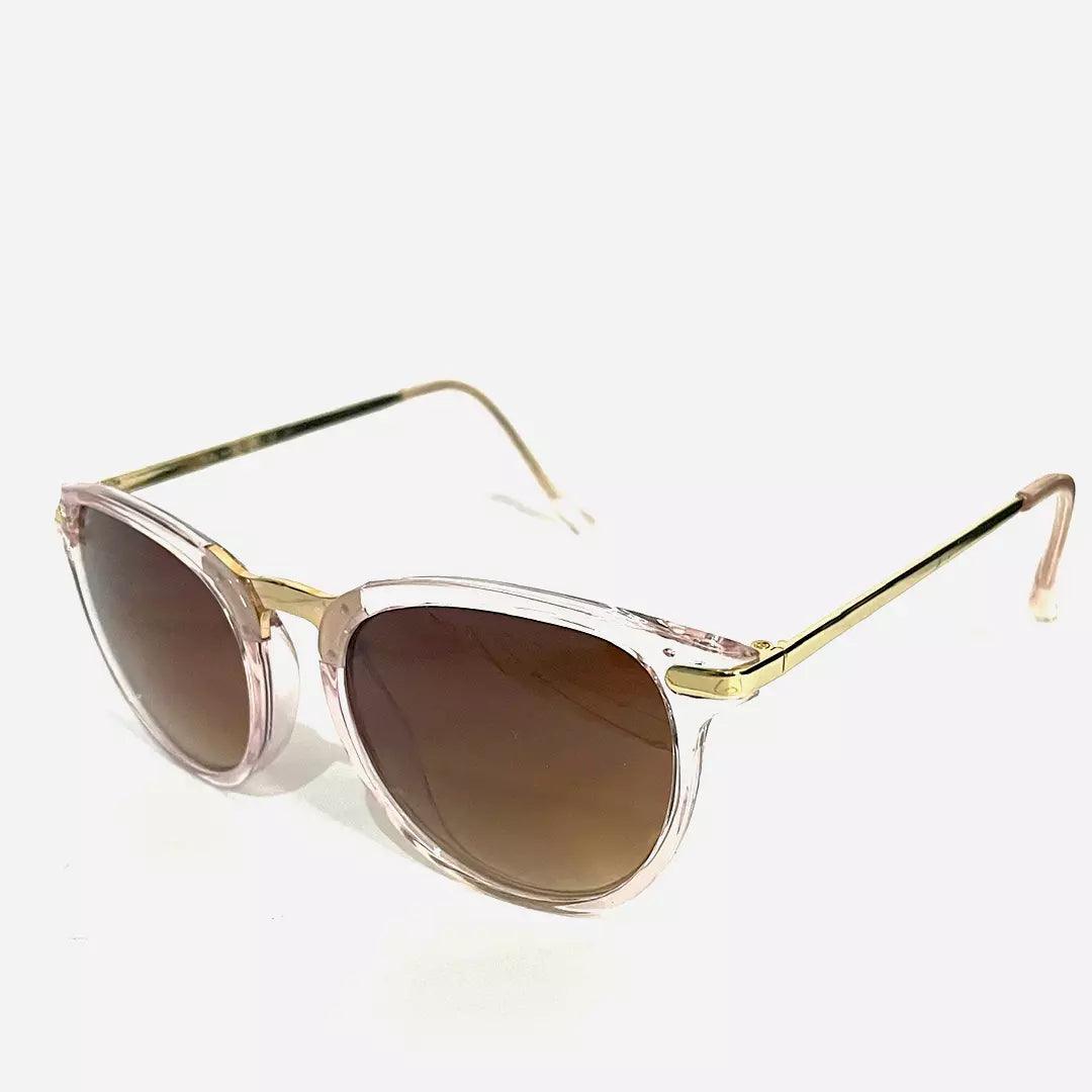 Óculos de sol Meteor Ray com armação transparente rosada, hastes douradas sofisticadas e lentes marrons graduais, combinando elegância e proteção contra os raios solares.