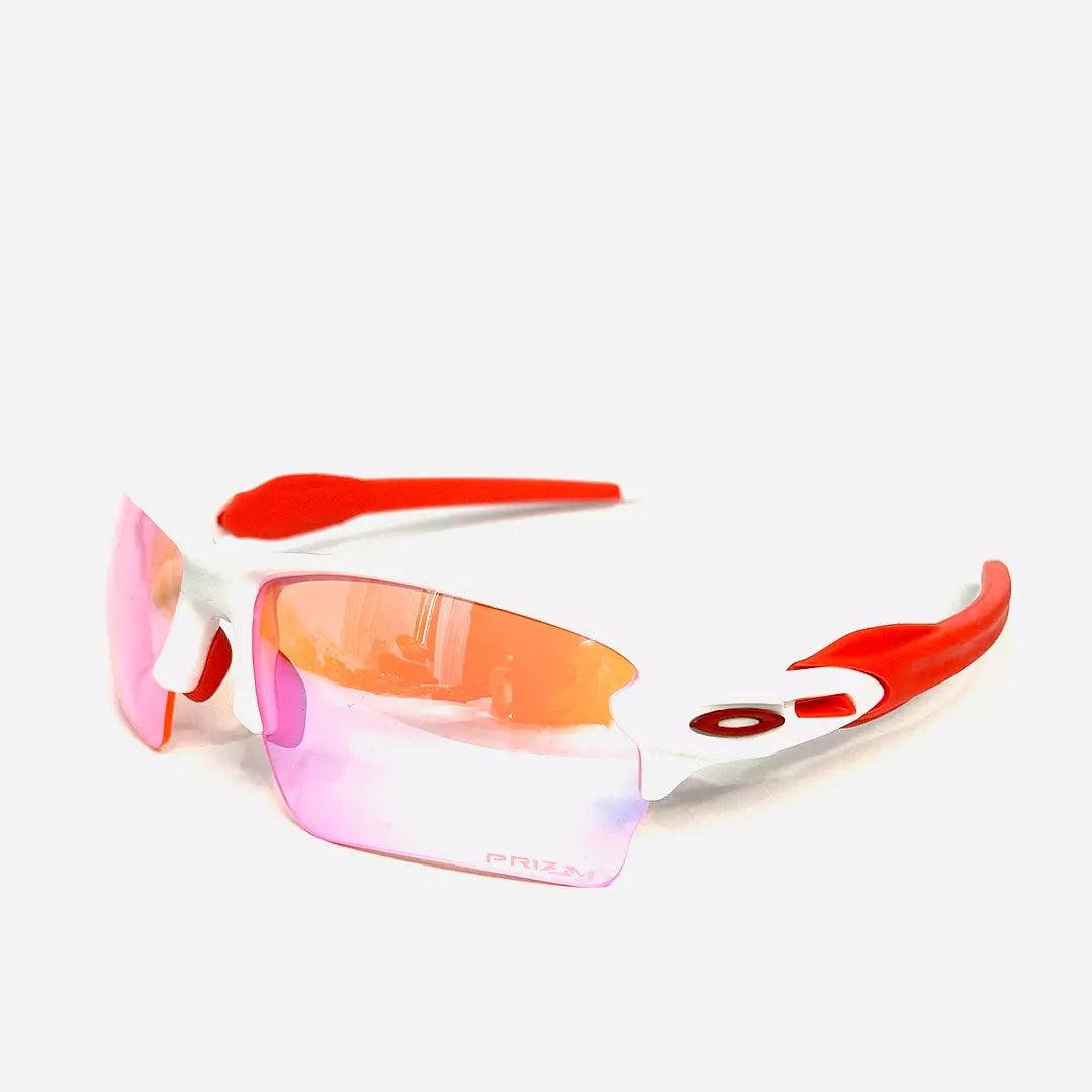 Óculos de sol Racer Rose White com armação branca e detalhes em vermelho, design esportivo e moderno. Lentes espelhadas em tom rosa oferecem proteção UV e estilo diferenciado.